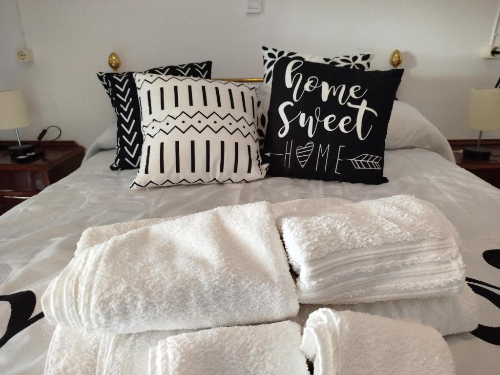 a bed with white towels and pillows on it at VILLA ROBLES in Santisteban del Puerto