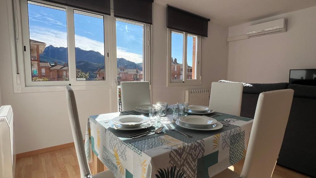 a dining room with a table and chairs with a view at Apartament per 4 al Berguedà in Sant Jordi de Cercs