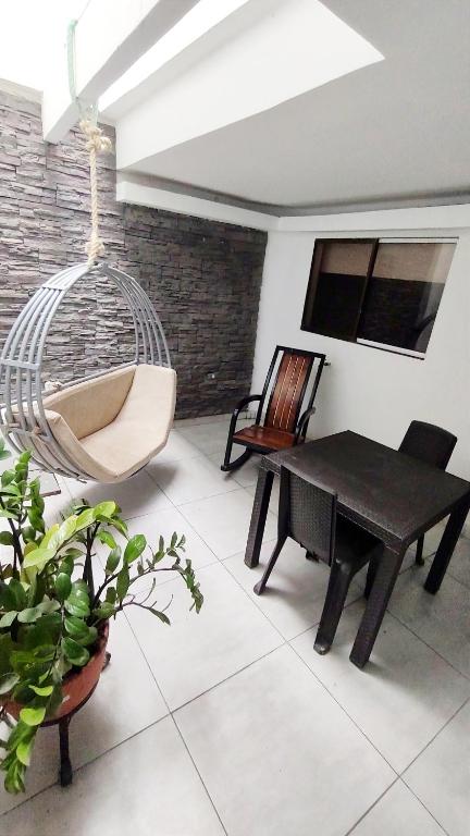 a room with a hammock and a table and a chair at Hotel Tranvia in Santa Marta