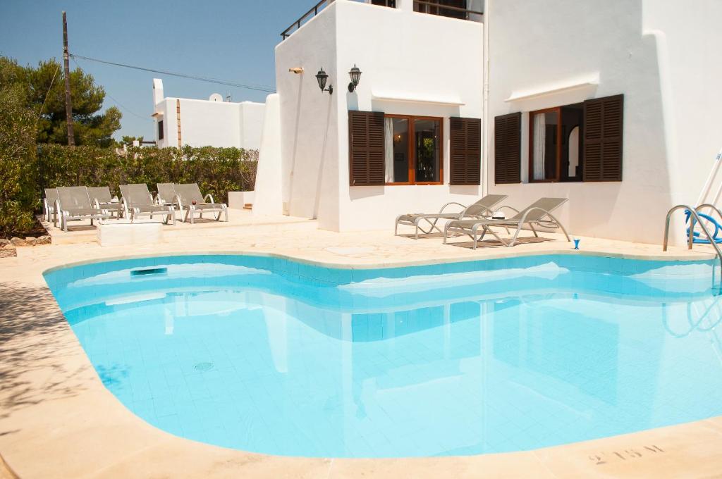 a swimming pool in front of a house at Villa Solana in Portopetro