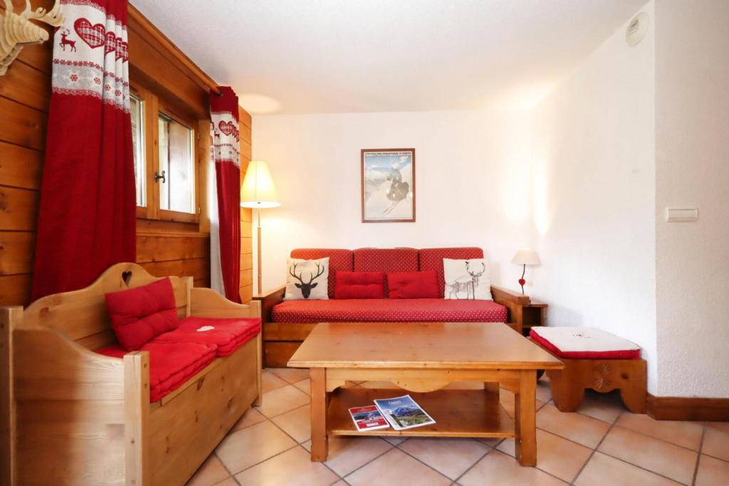 un salon avec un canapé rouge et une table dans l'établissement Résidence Les Hauts De Chavants - Hauts de Chavants Berard 04 MAE-6426, aux Houches