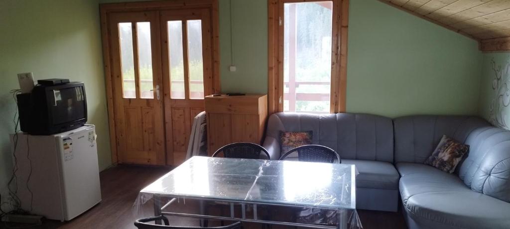 a living room with a couch and a coffee table at Békény Kulcsosház in Gheorgheni
