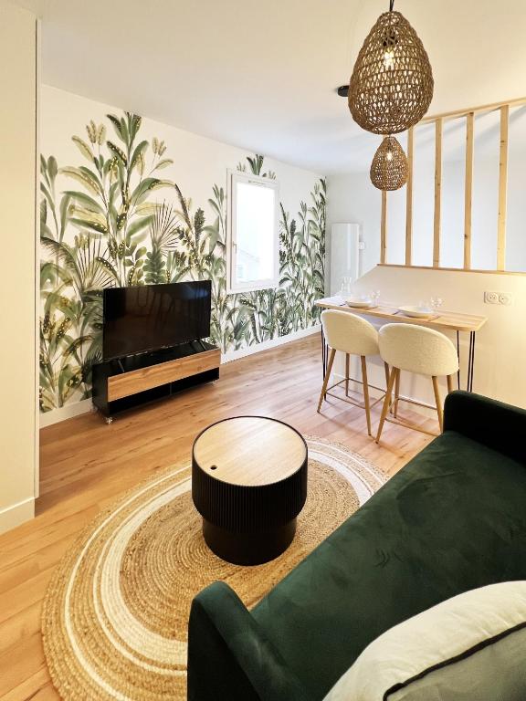 un salon avec un canapé vert et une table dans l'établissement Jungle home, à Rodez