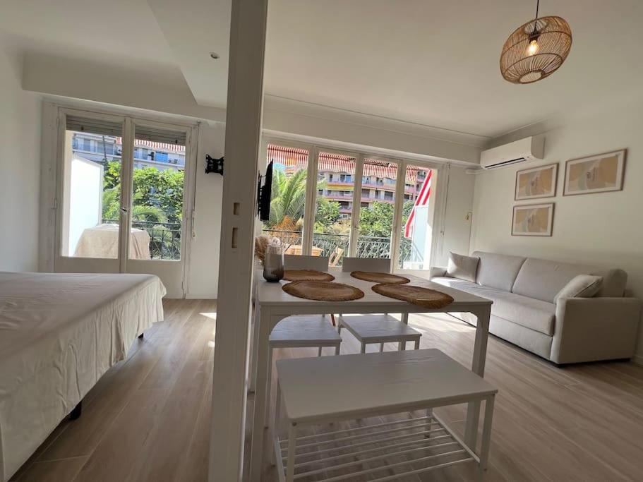 a bedroom with a bed and a table and a couch at Magnifique T2 proche mer et ville refait à neuf avec terrasse in Menton