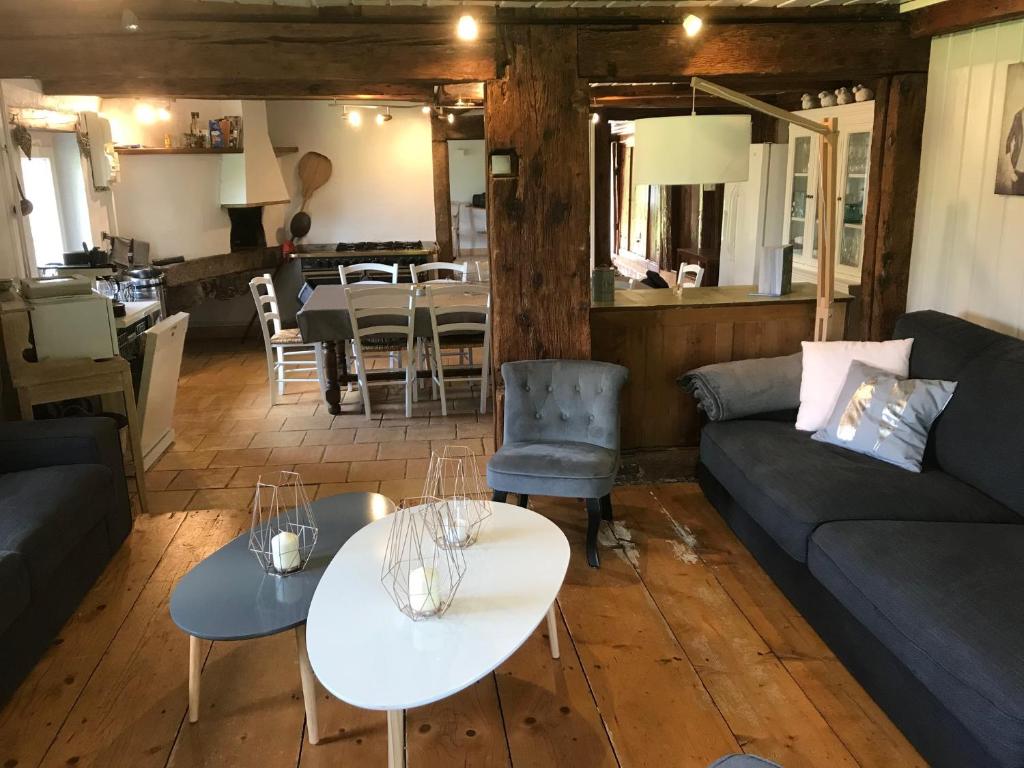 a living room with a couch and two tables at Ferme de Chenezeau - 15 personnes , 7 chambres in Gérardmer