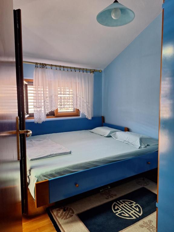 Un dormitorio azul con una cama con ventana. en Adriatic Luxury Flat, en Budva