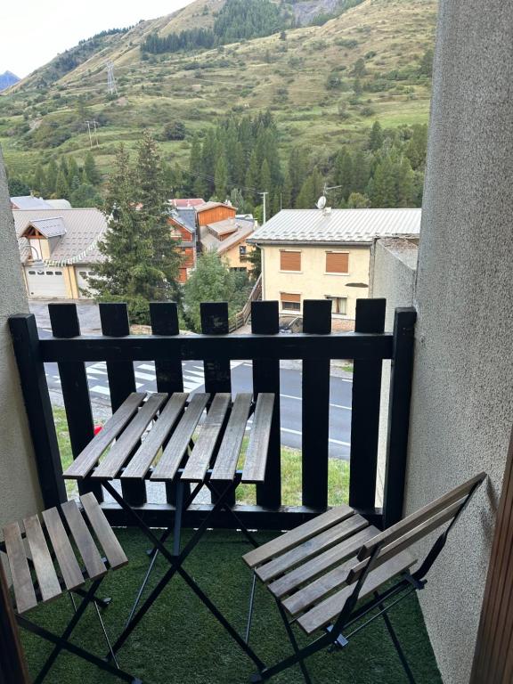 - une table de pique-nique et des chaises sur un balcon avec vue dans l'établissement Chez Margaux a Colchique, à Sainte-Marie-de-Vars