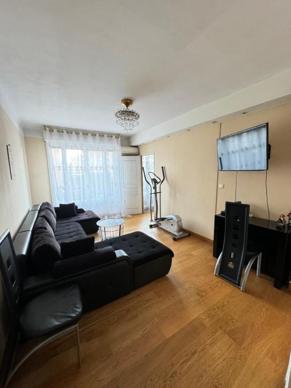 Il comprend un salon doté d'un canapé noir et d'une télévision à écran plat. dans l'établissement Appartement proche métro la Timone pour 4 pers Avec 2ch, à Marseille