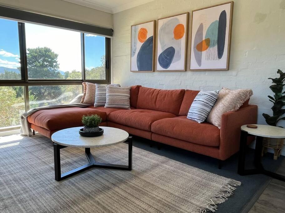 una sala de estar con un sofá y una mesa en Cobbers Rest, en Jindabyne