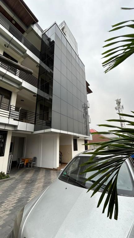 a white car parked in front of a building at Mubi House in Kinshasa