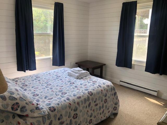 um quarto com uma cama e duas janelas em Captain's Quarters em Avon