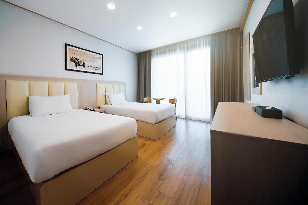 Postel nebo postele na pokoji v ubytování Shin Shin Hotel Jeju City
