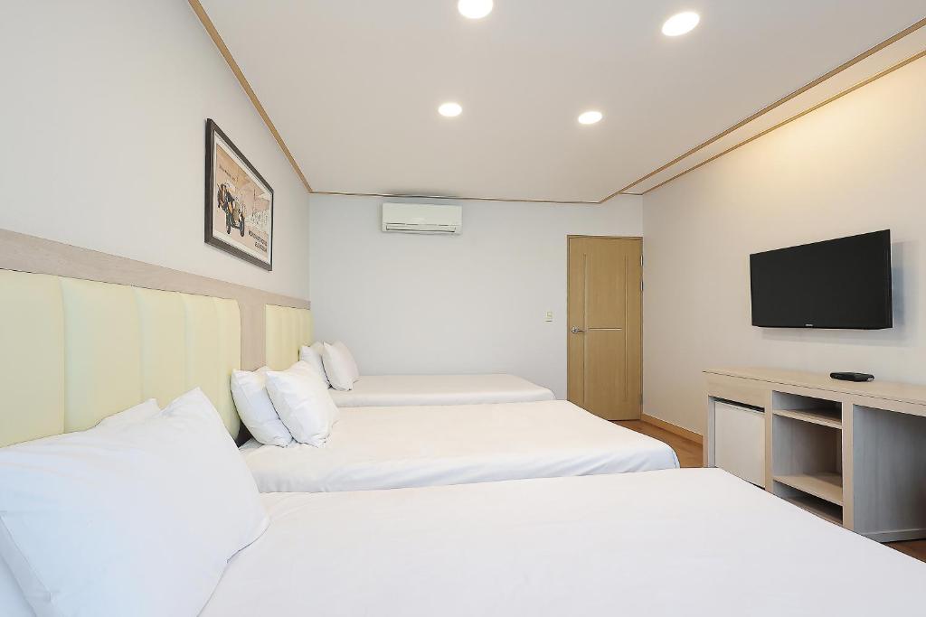 Postel nebo postele na pokoji v ubytování Shin Shin Hotel Jeju City