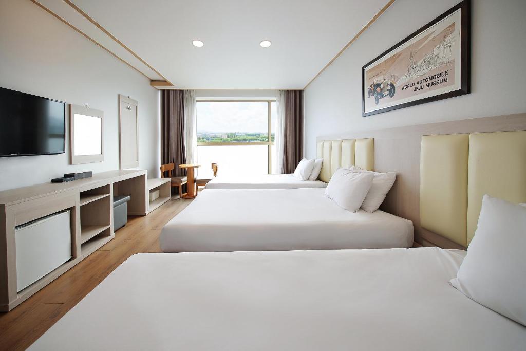 Postel nebo postele na pokoji v ubytování Shin Shin Hotel Jeju City