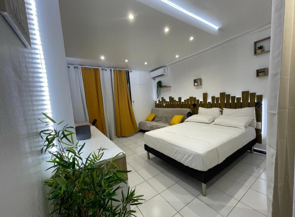 um quarto com uma cama e um sofá em Studio spacieux en bord de mer Bas du Fort Gosier em Le Gosier