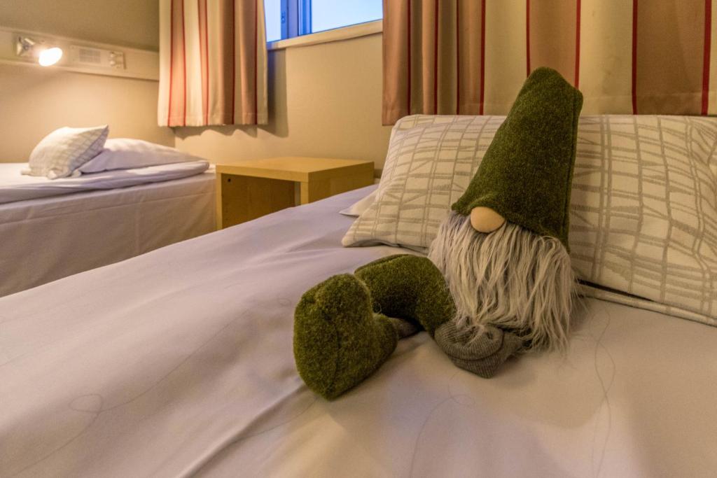 un animale di peluche giace su un letto di Santa's Hotel Rudolf a Rovaniemi
