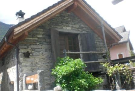 uma casa de pedra com uma janela e um telhado em Rustico Il Nido em Maggia