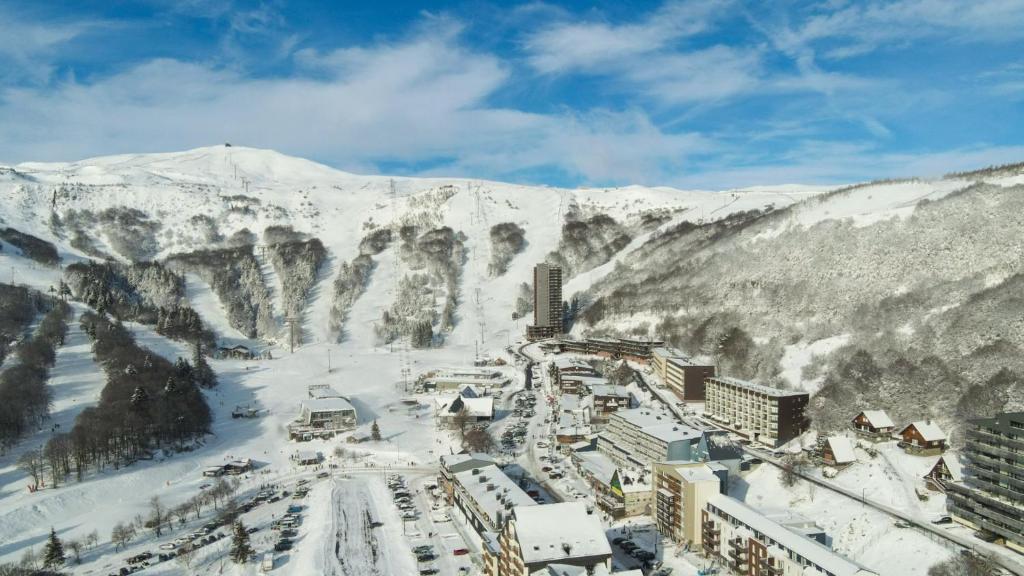 miasto pokryte śniegiem z górami w tle w obiekcie Le refuge des Gentianes w mieście Besse-et-Saint-Anastaise