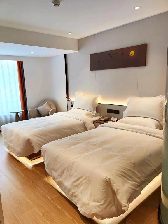 Postel nebo postele na pokoji v ubytování Yun Qi Hotel