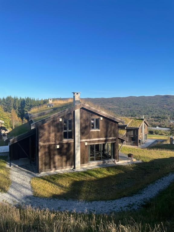 a wooden house on a hill with a view at Geilo - Ny og flott hytte på budalstølen in Geilo