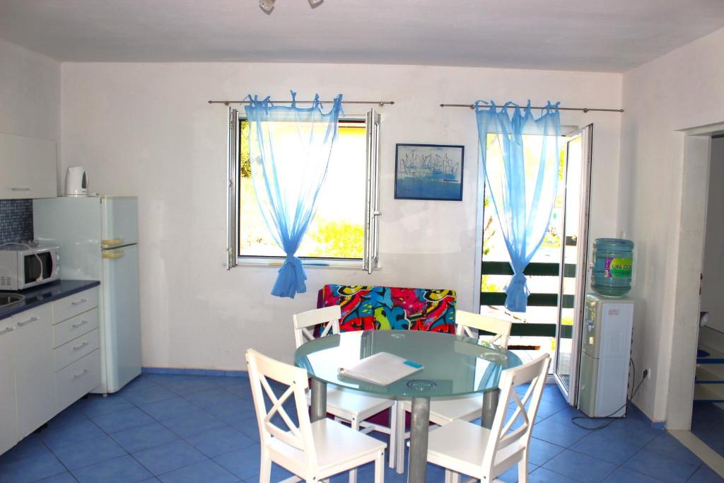 a kitchen with a table and chairs and a window at Vidoni - apartmani Roza in Zastražišće