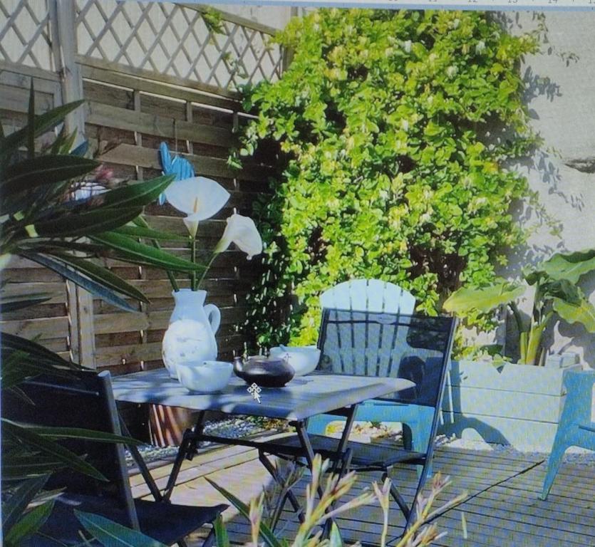 a table with two chairs and a vase on it at La grange du Manemeur in Quiberon