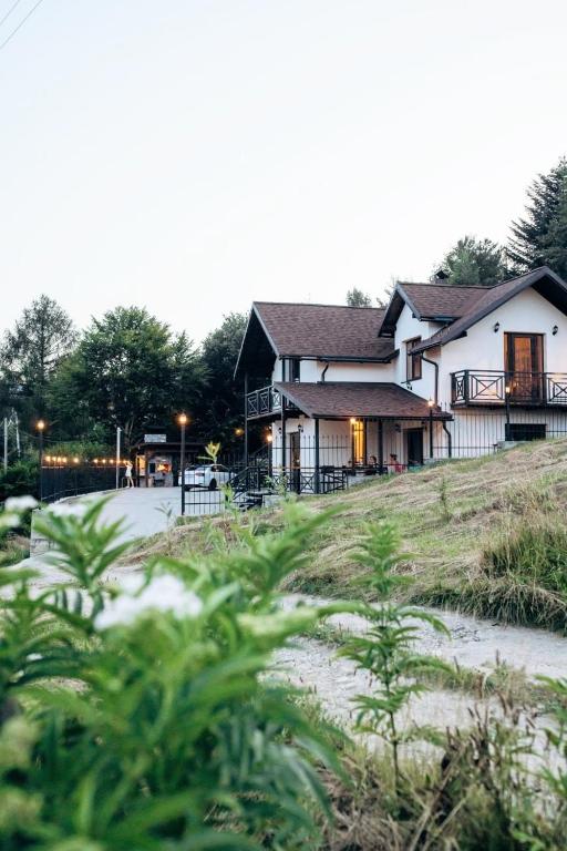 a large house on top of a hill with trees at Rubus resort in Yaremche
