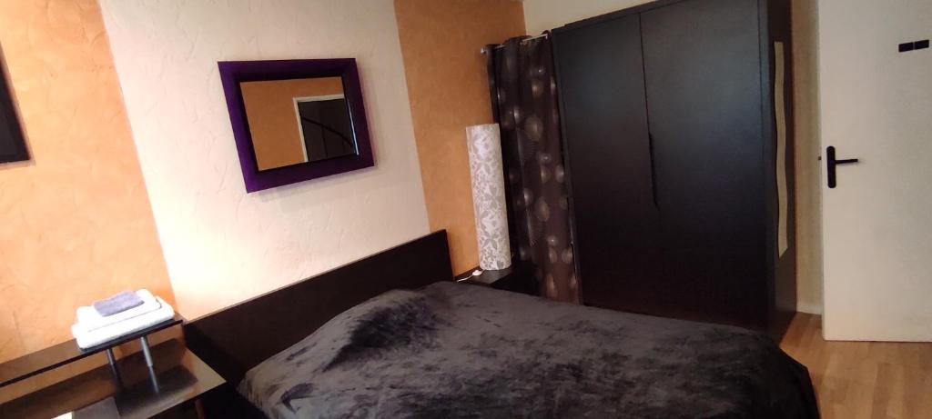 1 dormitorio con cama y armario negro en Chambre Grand lit Afrik, en Combs-la-Ville