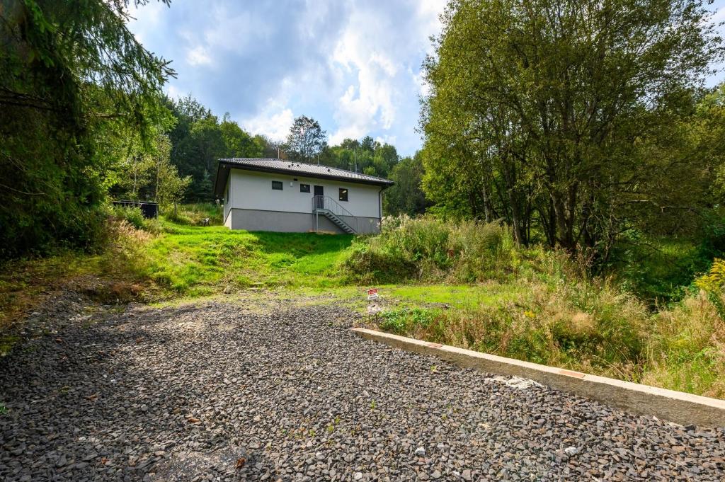 a small white house in the middle of a field at Chata Henry in Krásná