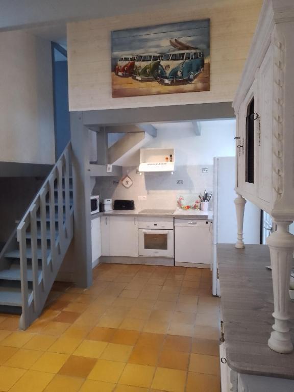 une cuisine avec des placards blancs et un escalier dans une maison dans l'établissement Maison 4 personnes Port La Flotte, à La Flotte