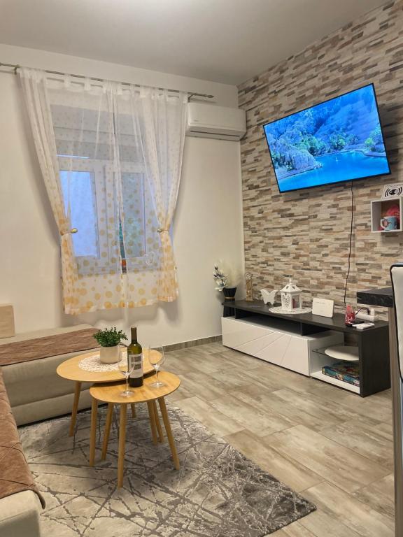 ヤブラナツにあるApartment Lucijaのレンガの壁にリビングルーム(テーブル、テレビ付)