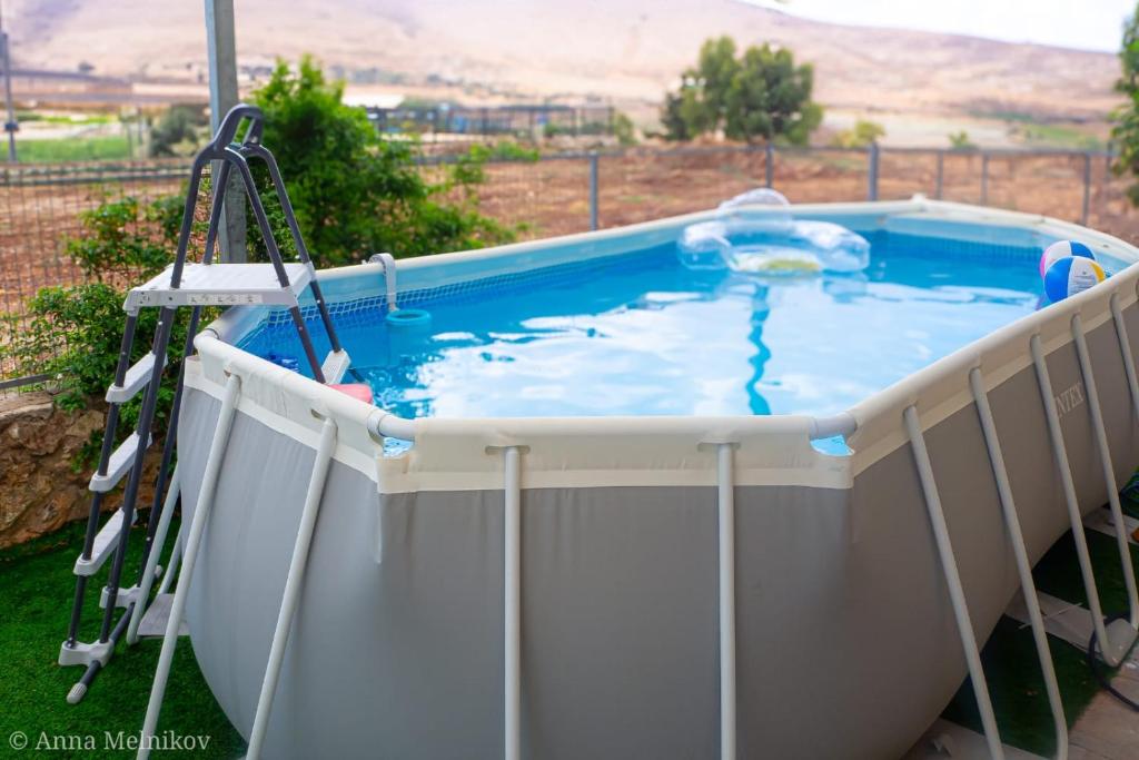 ein Whirlpool auf einer Veranda mit einer Leiter drumherum in der Unterkunft יפעת הגלבוע -סוויטות אירוח ברמה אחרת in Nurit