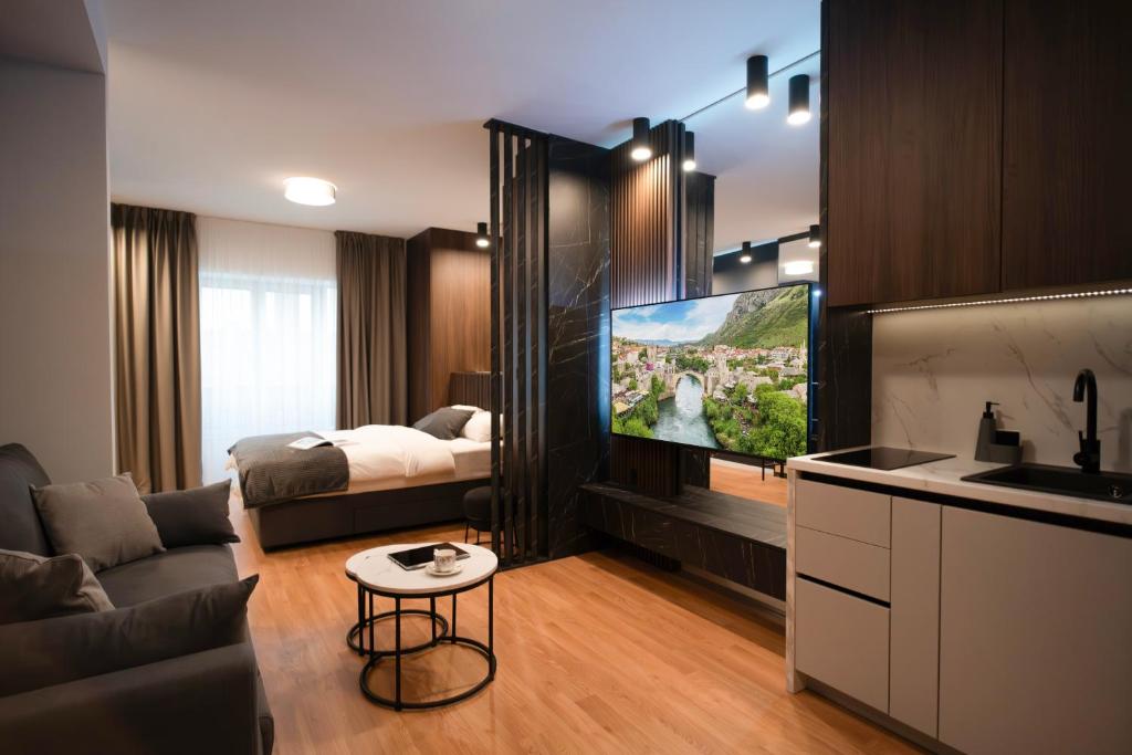 a living room with a tv and a bed at MoRent Apartments in Mostar
