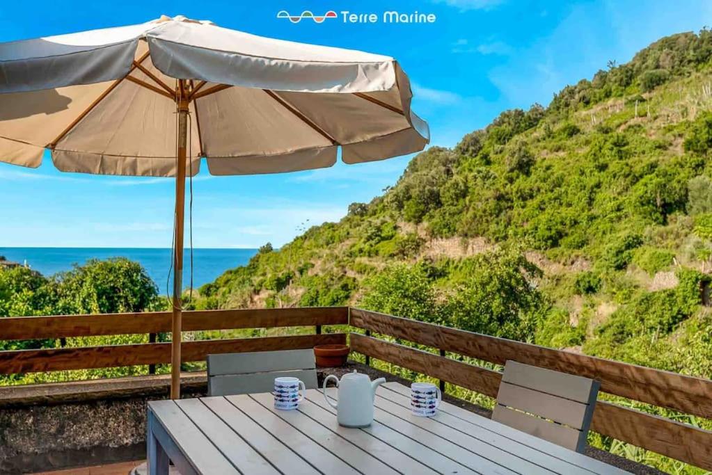 a table with an umbrella and the ocean at Il Frantoio, Terre Marine in Corniglia