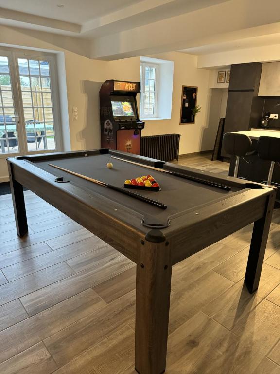 - une table de ping-pong dans le salon avec piscine dans l'établissement la veranda, à Fontenay-le-Pesnel