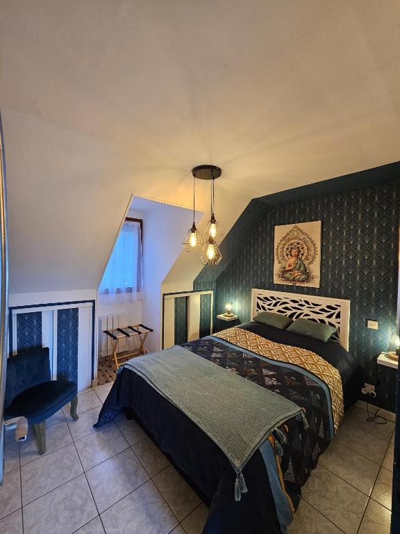 une chambre avec un grand lit et un lustre dans l'établissement Le nid de l'écureuil, à Selles-sur-Cher