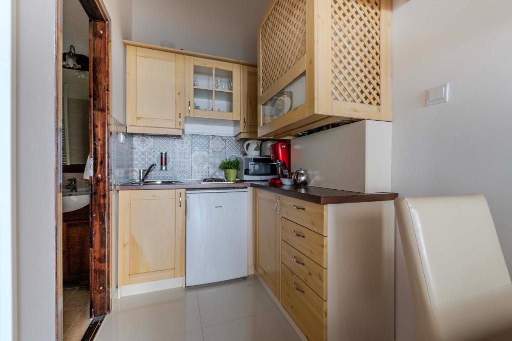 a small kitchen with wooden cabinets and a sink at Mirage Apartments Váci Street in Budapest