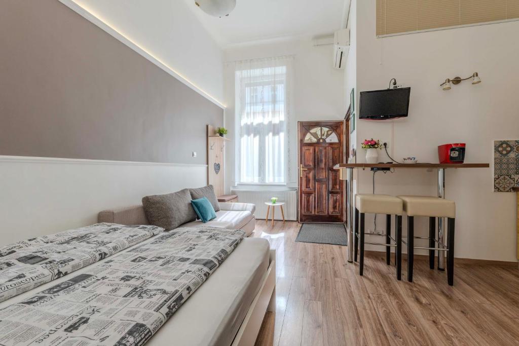 a bedroom with a bed and a couch and a tv at Mirage Apartments Váci Street in Budapest