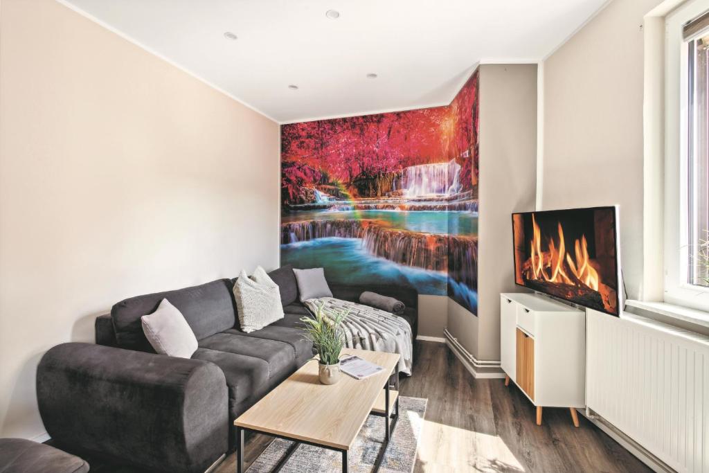 a living room with a couch and a painting on the wall at Harzquelle - Harzauszeit 2-4 Personen mit Garten in Thale