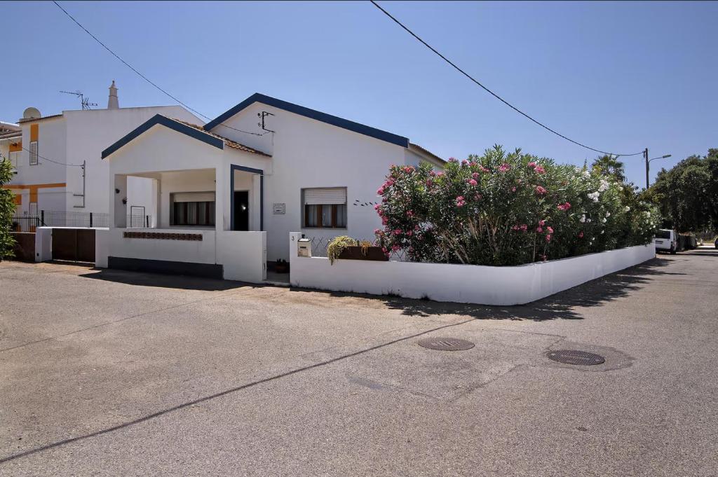 een wit huis met bloemen ervoor bij Casa Maria Beatriz in Manta Rota