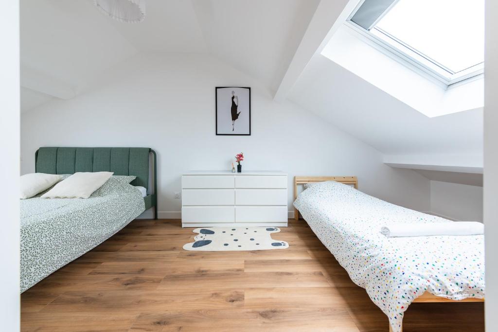 Un dormitorio con dos camas y una cómoda. en Le Cosy proche Disney, en Vaires-sur-Marne