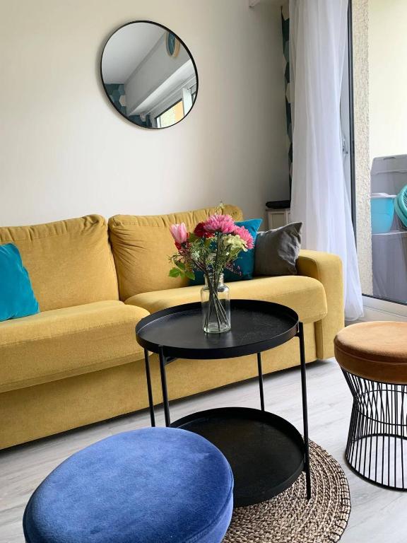 - un salon avec un canapé et un vase de fleurs sur une table dans l'établissement Cabourg, à Cabourg