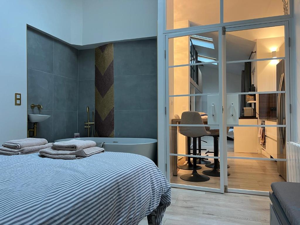 une chambre avec un lit et un bureau avec une chaise dans l'établissement Loft plein sud, à Paris