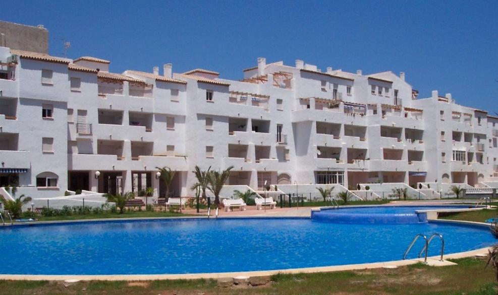 un gran edificio blanco con una piscina frente a él en Apartamentos Marinesco V.v., en La Manga del Mar Menor