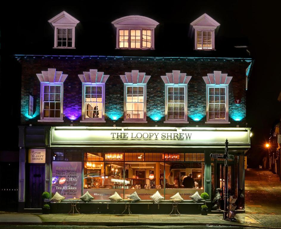 un edificio con una tienda delante de él por la noche en The Loopy Shrew, en Shrewsbury