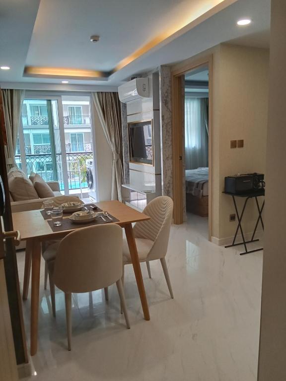 a dining room and living room with a table and chairs at Dusit grand park 2 in Jomtien Beach