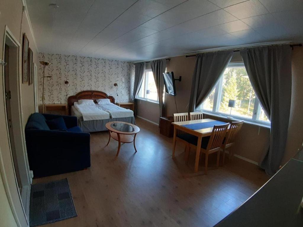 une chambre avec un lit, une table et un canapé dans l'établissement Majatalo Varis, à Vaala