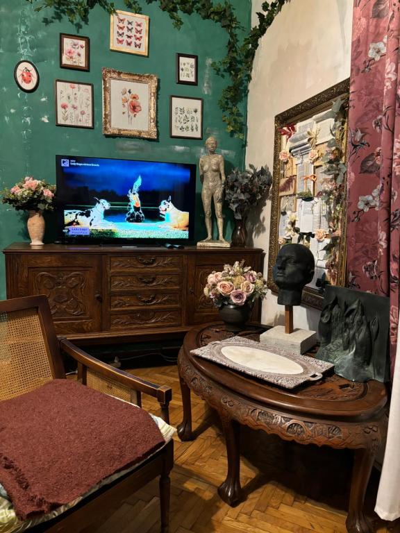 a living room with a tv and a table at Creative Apartment Kaleidoscope in Belgrade