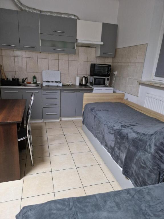 a kitchen with a bed and a table in it at SAWAGO Mini Apartament studio 23m2 - samodzielnie zameldowanie in Ciechanów