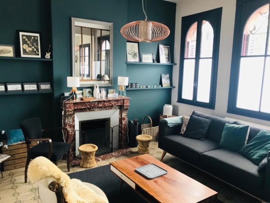 un salon avec un canapé et une cheminée dans l'établissement La petite Jacqueline, Maison classée 3 étoiles, hyper centre face plage, à Houlgate